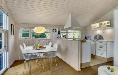 a kitchen and dining room with a table and chairs at Holiday Home Blokhus 9 in Blokhus