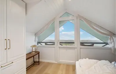 a bedroom with a large window with a bed and a table at 3 Bedroom Amazing Home In Højslev in Højslev