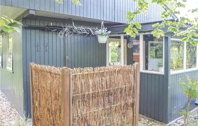 a fence in front of a blue house at Holiday Home Farsø 49 in Farsø