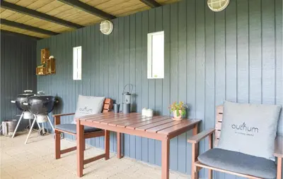 a wooden table and chairs in a room with a fan at Holiday Home Farsø 49 in Farsø