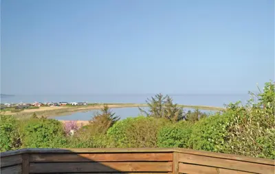 a wooden fence with a view of a body of water at Holiday Home Løgstør 53 in Løgstør