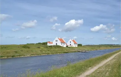 a couple of white houses on the side of a river at Holiday Home Løgstør 53 in Løgstør