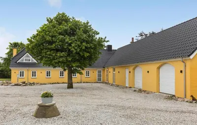 a yellow building with a tree in front of it at Stunning Home In Hurup Thy With Wifi in Boddum