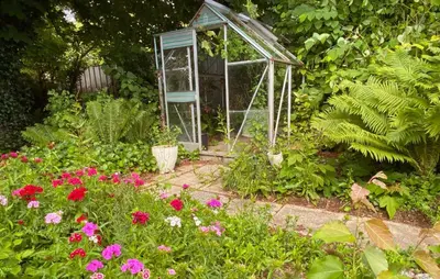 a greenhouse in the middle of a garden with flowers at 2 Bedroom Awesome Home In Vestervig in Vestervig