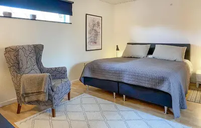a bedroom with a bed and a chair at 2 Bedroom Awesome Home In Vestervig in Vestervig
