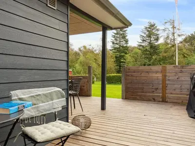 a patio with a table and chairs on a wooden deck at Holiday Home Jobst - 600m to the fjord by Interhome in Roslev
