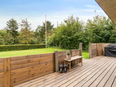 a wooden deck with a bench on it at Holiday Home Jobst - 600m to the fjord by Interhome in Roslev