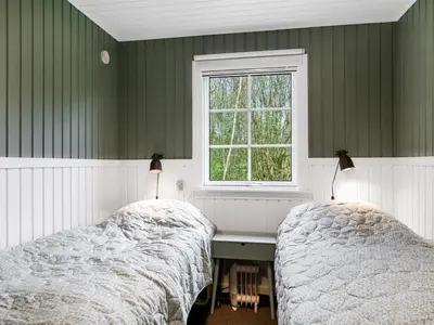 two beds in a bedroom with green walls and a window at Holiday Home Jobst - 600m to the fjord by Interhome in Roslev