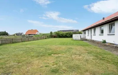 an empty yard next to a white house at 3 Bedroom Pet Friendly Home In Ulfborg in Ulfborg