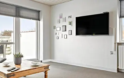 a living room with a flat screen tv on a wall at 3 Bedroom Pet Friendly Home In Ulfborg in Ulfborg