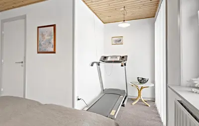 a bedroom with a treadmill next to a bed at 3 Bedroom Pet Friendly Home In Ulfborg in Ulfborg