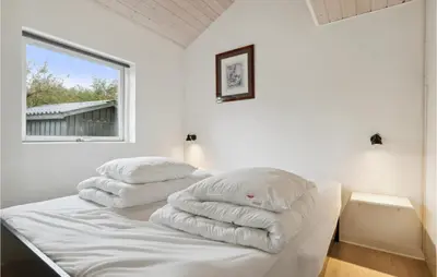 two pillows on a bed in a room with a window at Cozy Home In Struer With Wifi in Struer