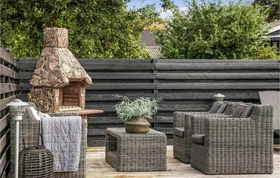 a patio with wicker chairs and a fireplace at Cozy Home In Løgstrup With Wifi in Løgstrup