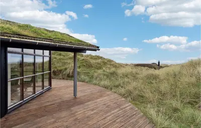 a building with a grass roof and a wooden walkway at Beautiful Home In Saltum in Saltum