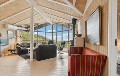 a living room with leather furniture and a large window at Beautiful Home In Saltum in Saltum
