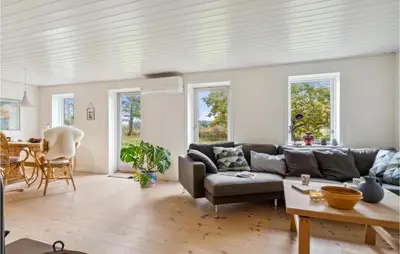 a living room with a couch and a table at 2 Bedroom Cozy Home In Fjerritslev in Fjerritslev