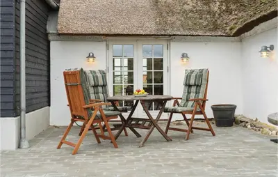 a wooden table and two chairs on a patio at 3 Bedroom Stunning Home In Lemvig in Lemvig