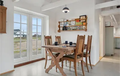 a dining room with a wooden table and chairs at 3 Bedroom Stunning Home In Lemvig in Lemvig