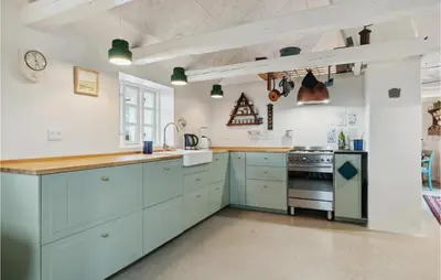 a kitchen with blue cabinets and a stove at 3 Bedroom Stunning Home In Lemvig in Lemvig
