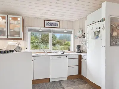 a kitchen with white cabinets and a white refrigerator at Holiday Home Sigbritt - 2-6km from the sea by Interhome in Blokhus