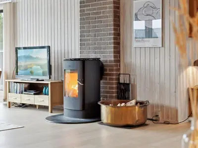 a living room with a fireplace and a tv at Holiday Home Anbritt - 1km from the sea by Interhome in Saltum