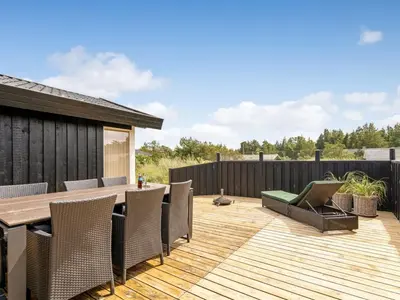 a deck with a wooden table and chairs at Holiday Home Anbritt - 1km from the sea by Interhome in Saltum
