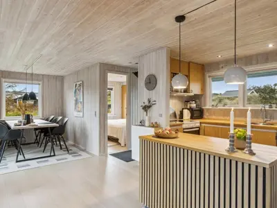 a kitchen and living room with a table and chairs at Holiday Home Anbritt - 1km from the sea by Interhome in Saltum