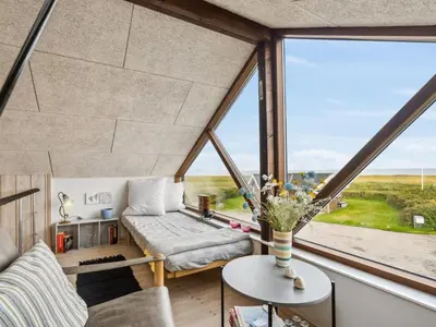 a room with a large window with a couch and a table at Holiday Home Benni - 75m to the fjord by Interhome in Løgstør