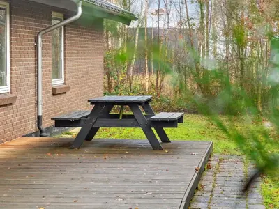 a picnic table on a wooden deck in front of a building at Holiday Home Patrik - 200m to the fjord by Interhome in Fur