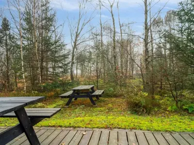 a picnic table and benches on a wooden deck at Holiday Home Patrik - 200m to the fjord by Interhome in Fur