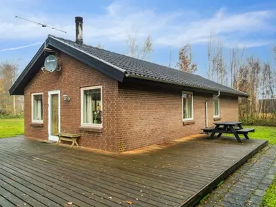 a brick house with a picnic table on a wooden deck at Holiday Home Patrik - 200m to the fjord by Interhome in Fur