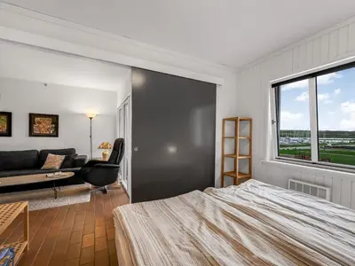 a bedroom with a bed and a couch and a window at Apartment Alvy - 100m to the fjord by Interhome in Lemvig