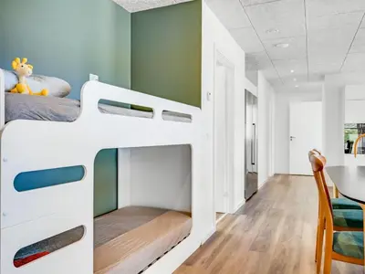 a childs bunk bed in a room with a table at Holiday Home Unge - 75m from the sea by Interhome in Torsted