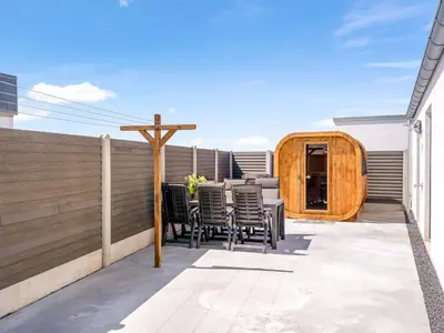 a patio with chairs and a wooden fence at Holiday Home Unge - 75m from the sea by Interhome in Torsted