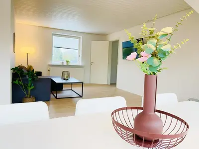 a vase filled with flowers in a living room at aday - Modern 3 bedrooms apartment in Svenstrup in Svenstrup
