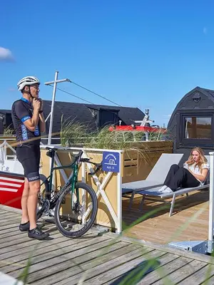 a man standing next to a bike on a dock at Boathouses dk - Besøg os direkte på hjemmesiden in Vinderup