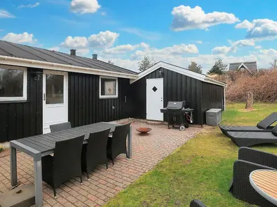 a patio with a table and chairs and a building at 4 star holiday home in Blokhus-By Traum in Blokhus