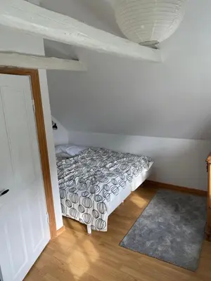 a bedroom with a bed in the corner of a room at Søbugten in Nykøbing Mors