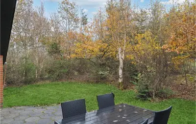 a wooden table with two chairs on a patio at Lovely Home In Hurup Thy With Wifi in Sønder Ydby