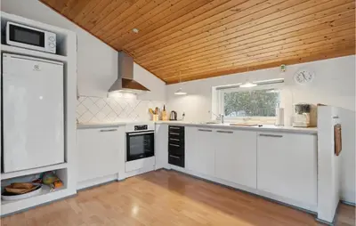 a kitchen with white cabinets and a wooden ceiling at Lovely Home In Hurup Thy With Wifi in Sønder Ydby