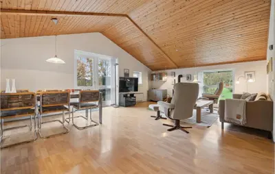 a living room with a wooden ceiling and a table and chairs at Lovely Home In Hurup Thy With Wifi in Sønder Ydby