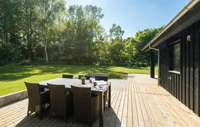 a wooden deck with a table and chairs on it at 3 Bedroom Cozy Home In Farsø in Farsø