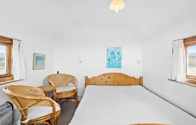 a bedroom with a bed and two chairs at Amazing Home In Frøstrup With Sauna in Frøstrup