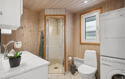 a small bathroom with a toilet and a shower at Beautiful Home In Vinderup With Sauna in Vinderup