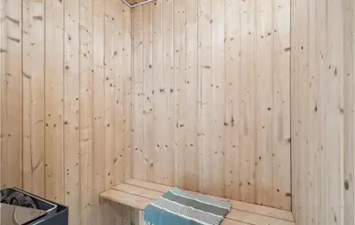 a wooden paneled sauna with a wooden wall at Beautiful Home In Vinderup With Sauna in Vinderup