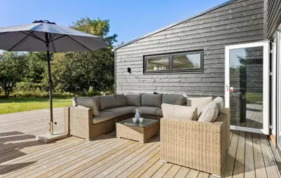 a patio with a couch and an umbrella on a deck at Amazing Home In Spøttrup With Wifi in Spottrup