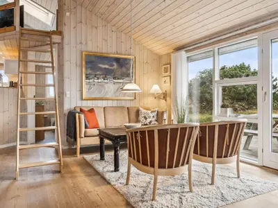 a living room with a ladder and a couch at Holiday Home Bruni - 400m from the sea by Interhome in Frøstrup
