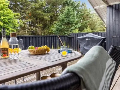 a wooden table with a basket of fruit on a deck at Holiday Home Thrineke - 600m from the sea by Interhome in Saltum