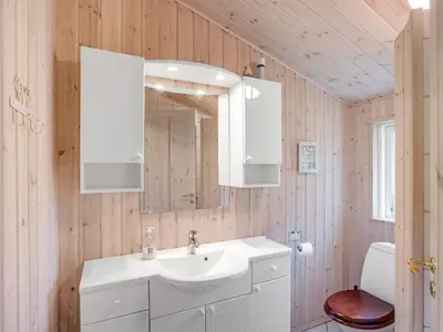 a bathroom with a sink and a mirror at Holiday Home Thrineke - 600m from the sea by Interhome in Saltum
