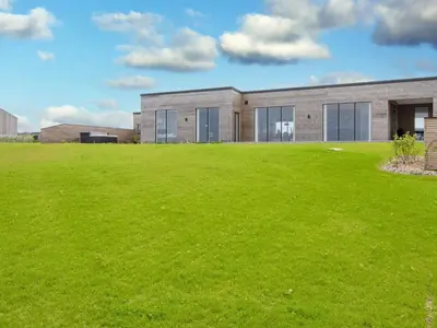 a large grass field in front of a building at 5 star holiday home in Lemvig-By Traum in Lemvig